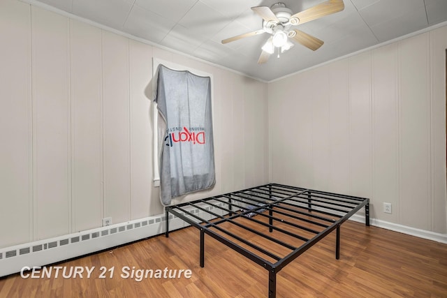 bedroom featuring hardwood / wood-style flooring, ceiling fan, ornamental molding, and baseboard heating