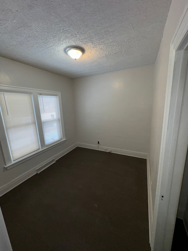 unfurnished room featuring a textured ceiling