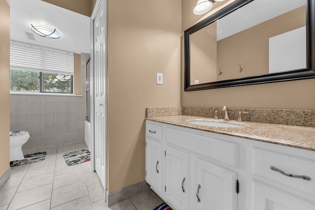 bathroom with vanity, tile patterned flooring, tile walls, and a shower