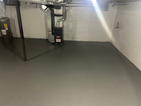 basement featuring electric water heater and heating unit