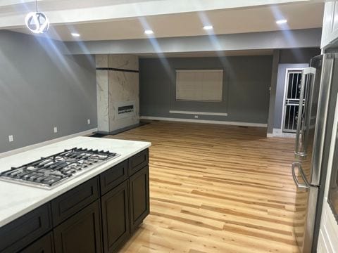 kitchen with pendant lighting, stainless steel appliances, light hardwood / wood-style floors, and white cabinets