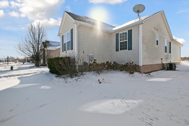 snow covered property featuring central AC unit