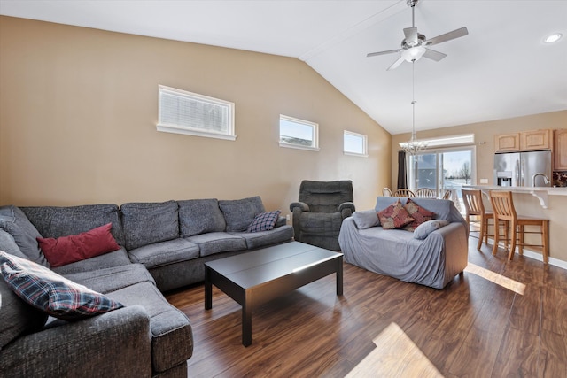 living room with ceiling fan with notable chandelier, vaulted ceiling, and dark hardwood / wood-style floors