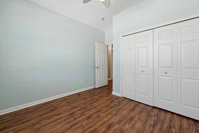 unfurnished bedroom with vaulted ceiling, dark hardwood / wood-style flooring, ceiling fan, and a closet