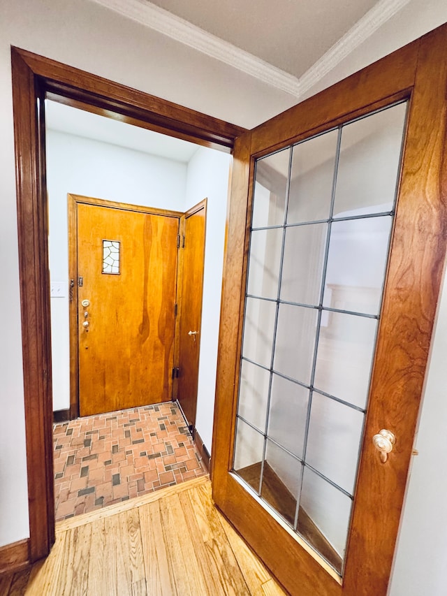 doorway to outside with crown molding and light hardwood / wood-style flooring