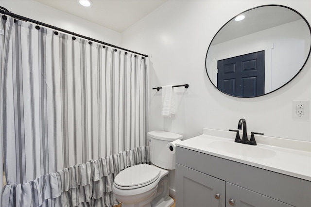 bathroom with walk in shower, vanity, and toilet