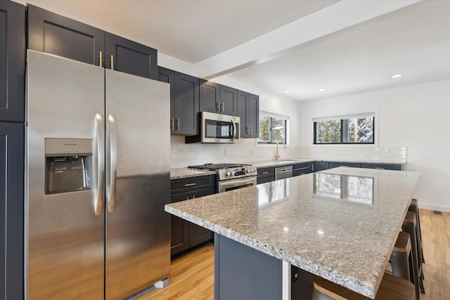 kitchen featuring stainless steel appliances, a center island, and a breakfast bar area