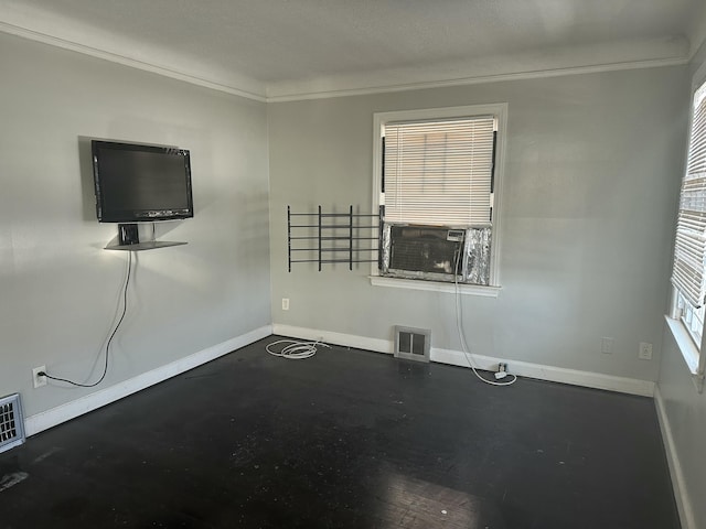 unfurnished living room featuring ornamental molding, cooling unit, visible vents, and baseboards