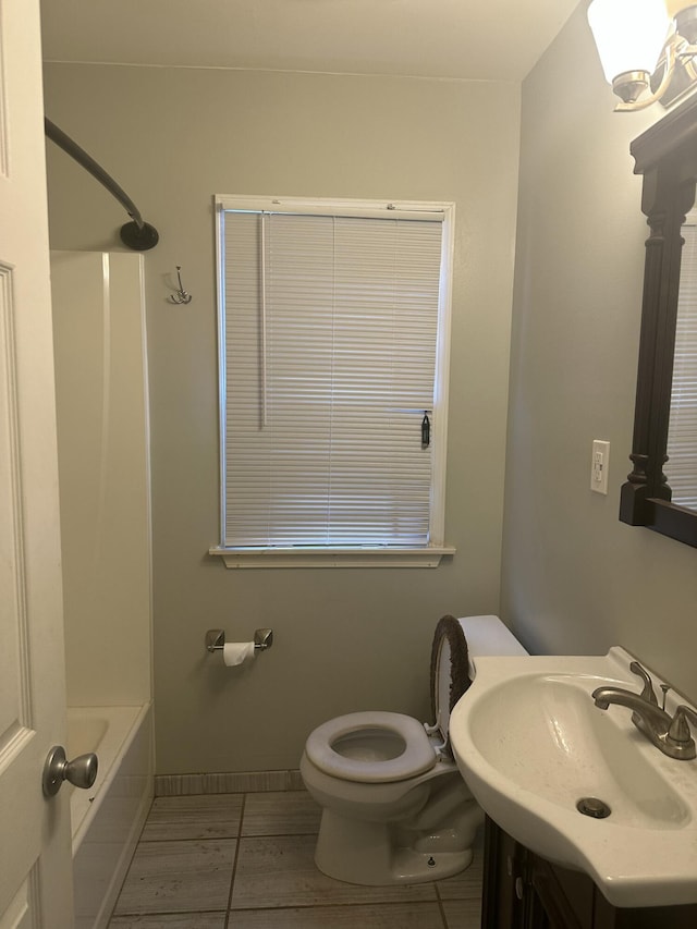 bathroom with toilet, tile patterned flooring, baseboards, and vanity