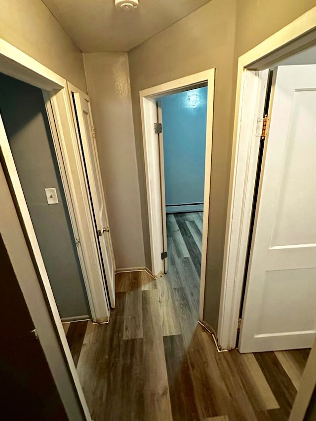 hallway with hardwood / wood-style floors and baseboard heating