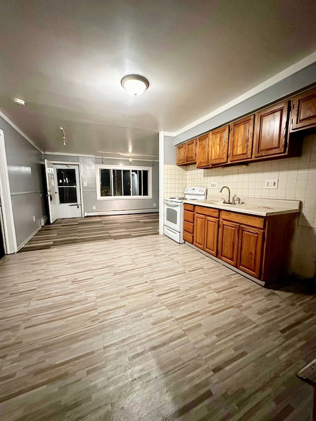 kitchen featuring sink, backsplash, electric range, and light hardwood / wood-style floors