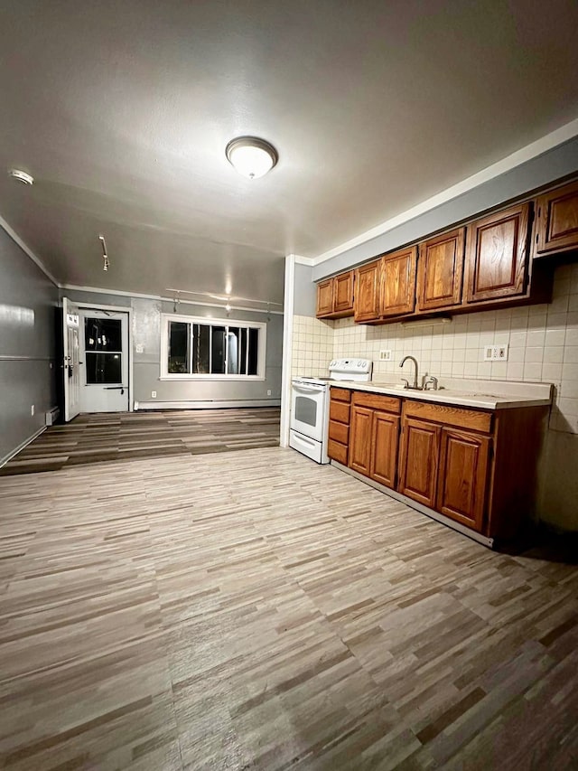 kitchen featuring white range with electric cooktop, light hardwood / wood-style floors, sink, and decorative backsplash