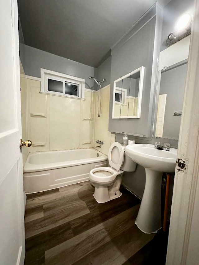 full bathroom featuring sink, wood-type flooring, bathtub / shower combination, and toilet