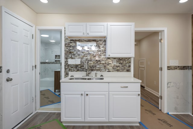 kitchen featuring sink, decorative backsplash, dark wood-type flooring, and white cabinets