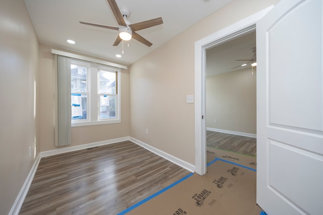 unfurnished room with dark hardwood / wood-style floors and ceiling fan