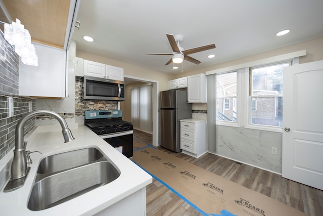 kitchen featuring white cabinetry, appliances with stainless steel finishes, sink, and light hardwood / wood-style flooring