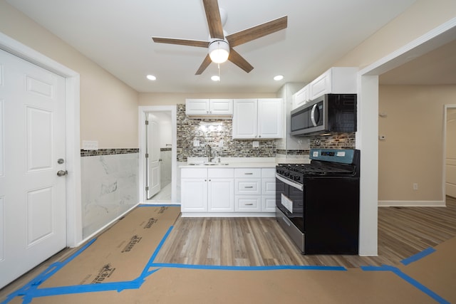 kitchen featuring stainless steel appliances, sink, white cabinets, and light hardwood / wood-style flooring