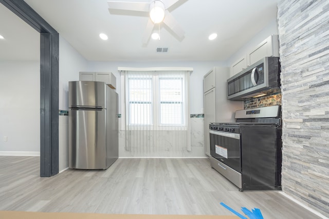 kitchen featuring stainless steel appliances, ceiling fan, white cabinets, and light wood-type flooring