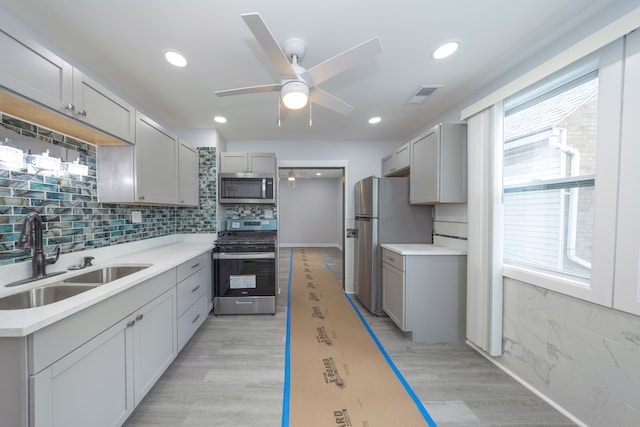 kitchen with light hardwood / wood-style flooring, sink, gray cabinets, and stainless steel appliances