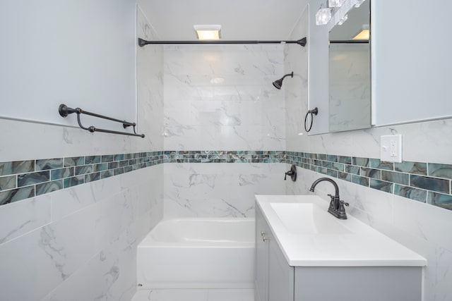 bathroom featuring vanity, tiled shower / bath combo, and tile walls