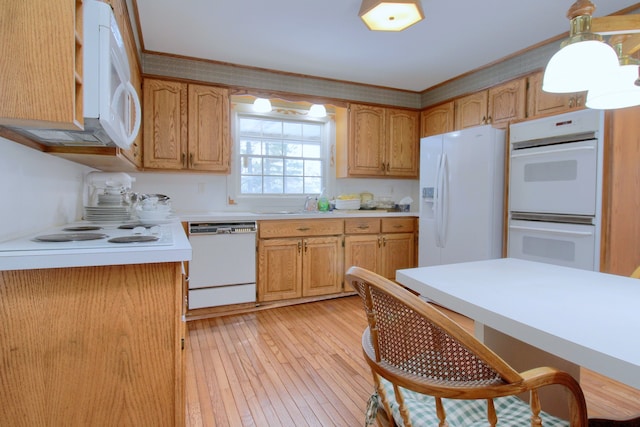 kitchen featuring ornamental molding, sink, white appliances, and light hardwood / wood-style floors