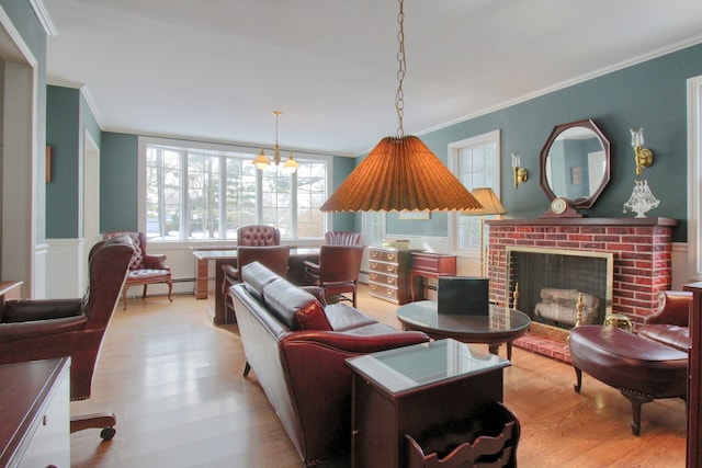 living room with a brick fireplace, crown molding, a baseboard radiator, and light hardwood / wood-style floors