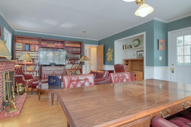 dining area featuring ornamental molding, built in features, and light wood-type flooring