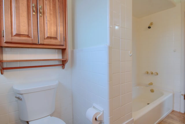 bathroom featuring hardwood / wood-style flooring, tile walls, and toilet