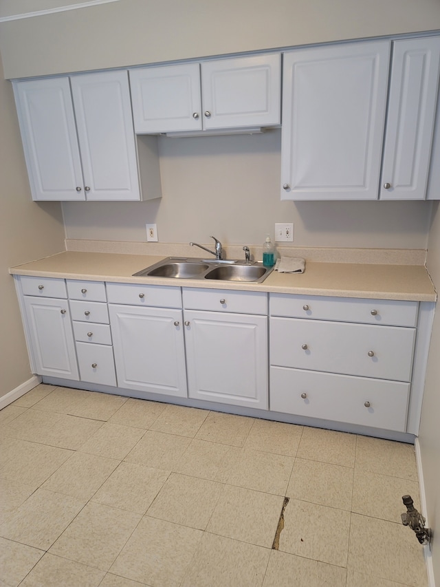 kitchen with white cabinetry, sink, and light tile patterned flooring