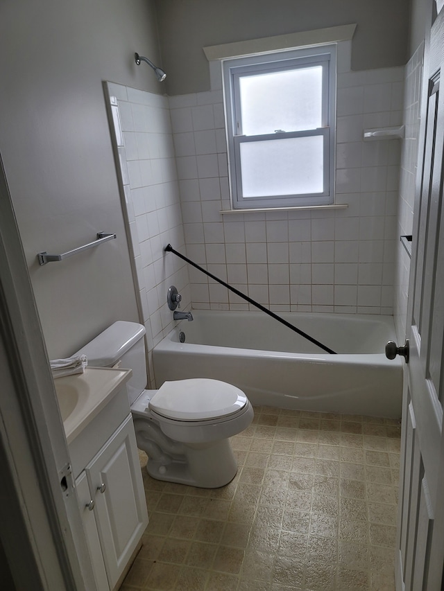 full bathroom featuring vanity, tiled shower / bath, and toilet