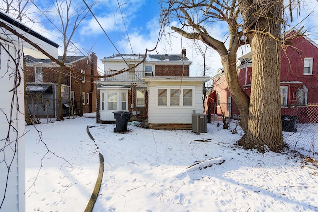 snow covered property with central AC unit