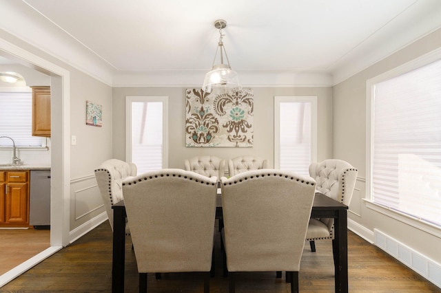 dining room featuring crown molding, dark hardwood / wood-style flooring, and sink