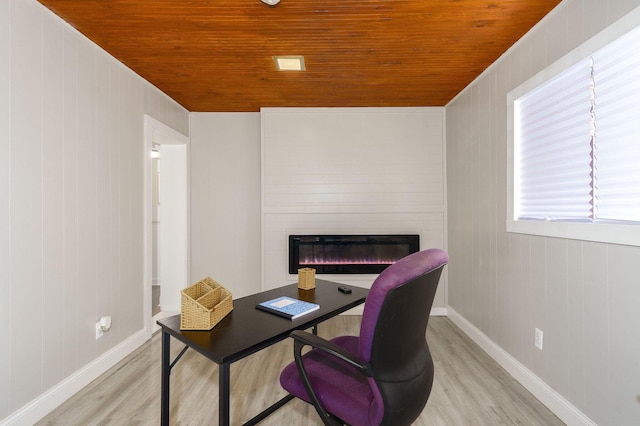 office area with wood ceiling, a fireplace, light hardwood / wood-style floors, and wooden walls