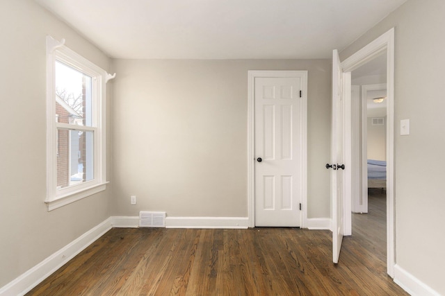 unfurnished room with dark hardwood / wood-style flooring