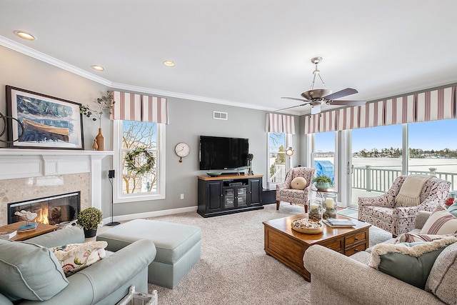 living area featuring visible vents, light colored carpet, crown molding, a healthy amount of sunlight, and a fireplace