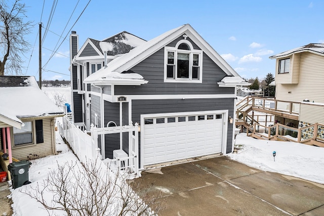 view of front of home featuring a garage, a chimney, and fence