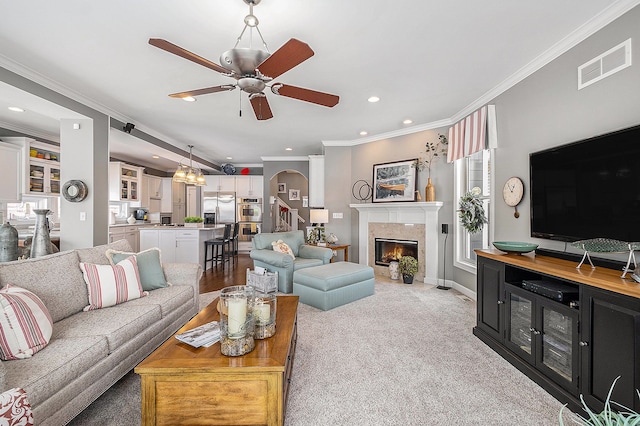 living area featuring crown molding, a fireplace, recessed lighting, visible vents, and ceiling fan