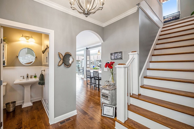 hallway with a chandelier, visible vents, stairs, dark wood-style floors, and crown molding