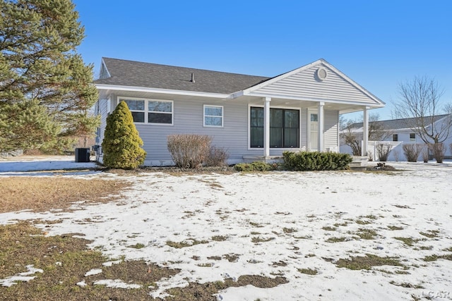 snow covered property featuring covered porch and central air condition unit