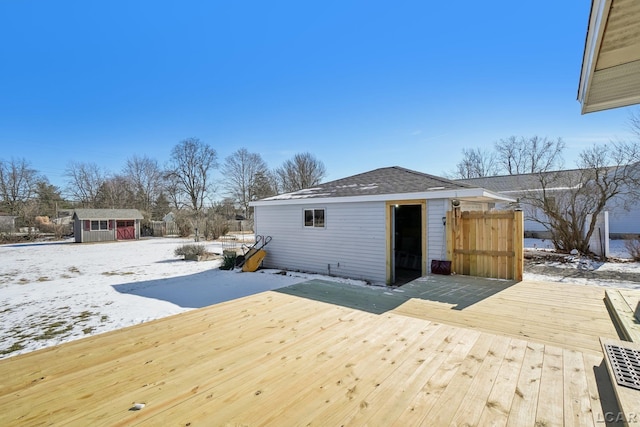 snow covered deck featuring a shed