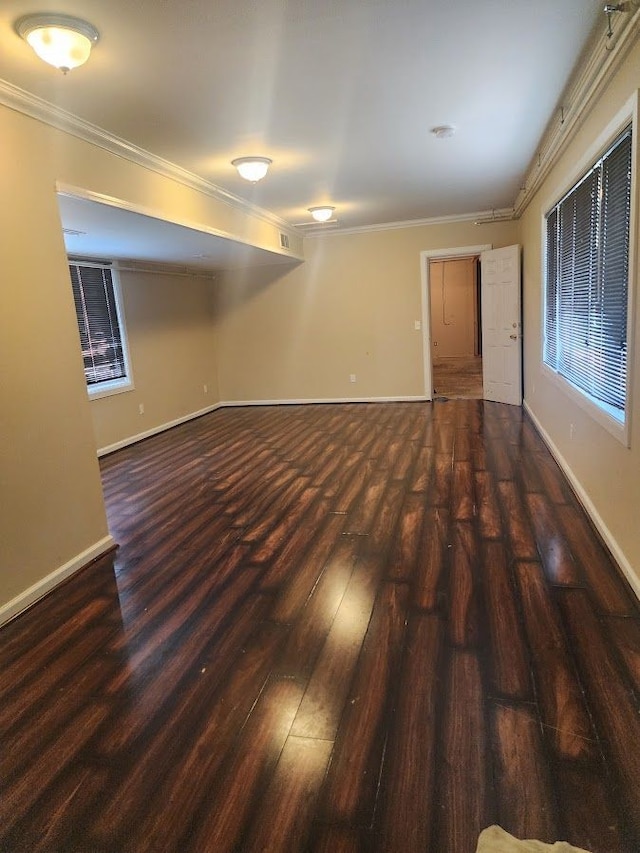 empty room featuring crown molding and dark wood-type flooring