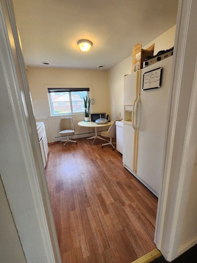 interior space with wood-type flooring and a baseboard heating unit