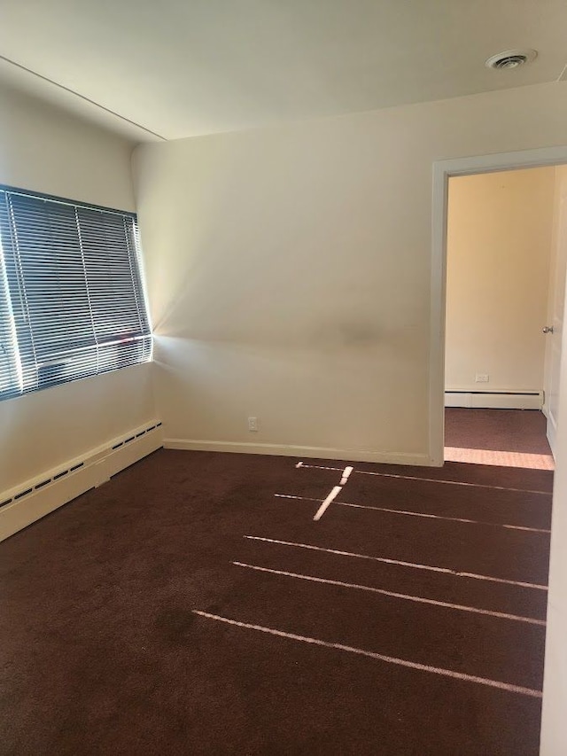 unfurnished room featuring a baseboard radiator and dark carpet