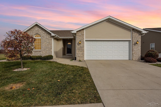 ranch-style house featuring a garage and a lawn