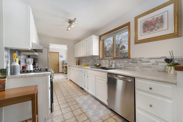 kitchen featuring sink, white cabinetry, light tile patterned floors, stainless steel dishwasher, and track lighting