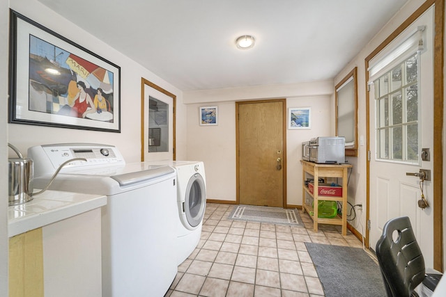 clothes washing area with light tile patterned flooring and separate washer and dryer