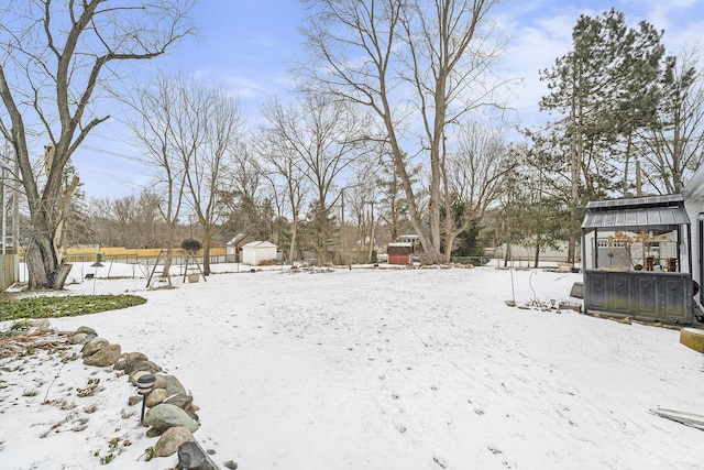 yard layered in snow with a shed