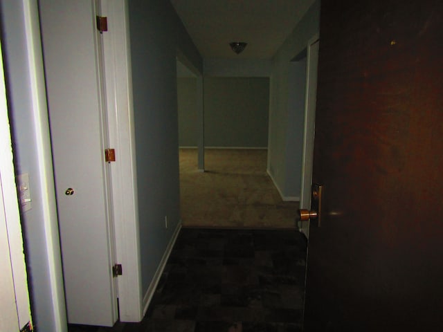 hallway featuring dark carpet