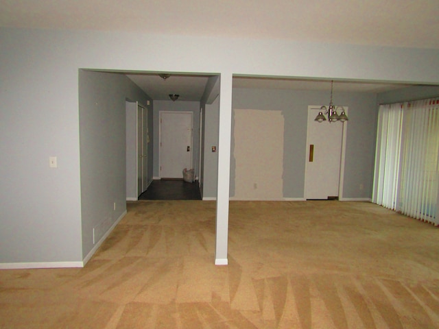 carpeted spare room with a chandelier