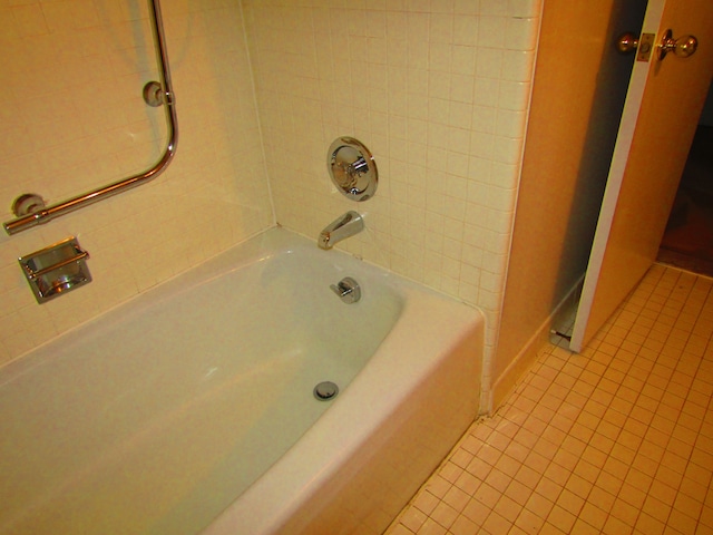 bathroom featuring tiled shower / bath combo and tile patterned flooring